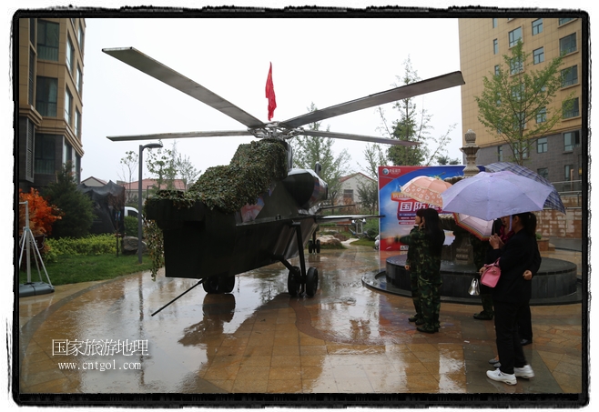 小區(qū)突然出現(xiàn)“飛機坦克”，其中殲15艦載戰(zhàn)斗機一架、99式主戰(zhàn)坦克一輛、武直-10武裝直升機一架，吸引了眾多市民雨中圍觀、合影。